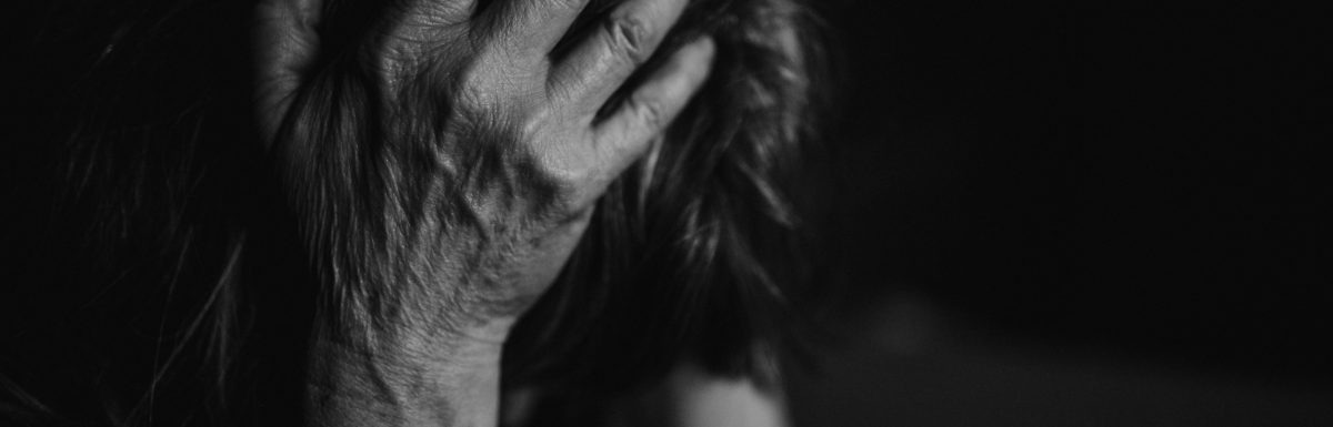 A woman in the midst of trauma, head held in her hands.
