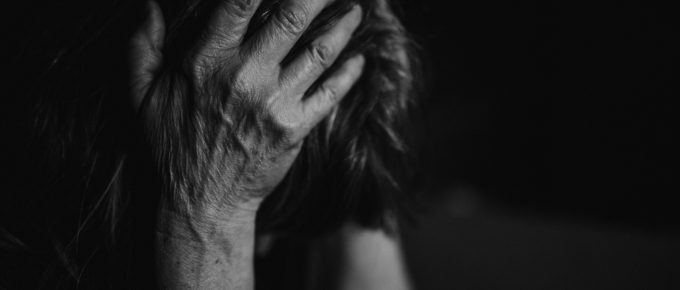 A woman in the midst of trauma, head held in her hands.