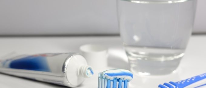 A tube of fluoride toothpaste and a loaded toothbrush.