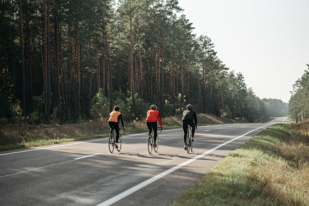 The Hormonal Key to Vibrant Health and Weight Harmony 2 Three female cyclists ride on a forest-lined road with clear skies above, their energy levels soaring as if propelled by the natural boost of hormone leptin.