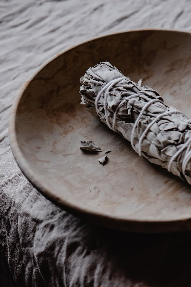 A bowl with a sage smudge for space clearing.